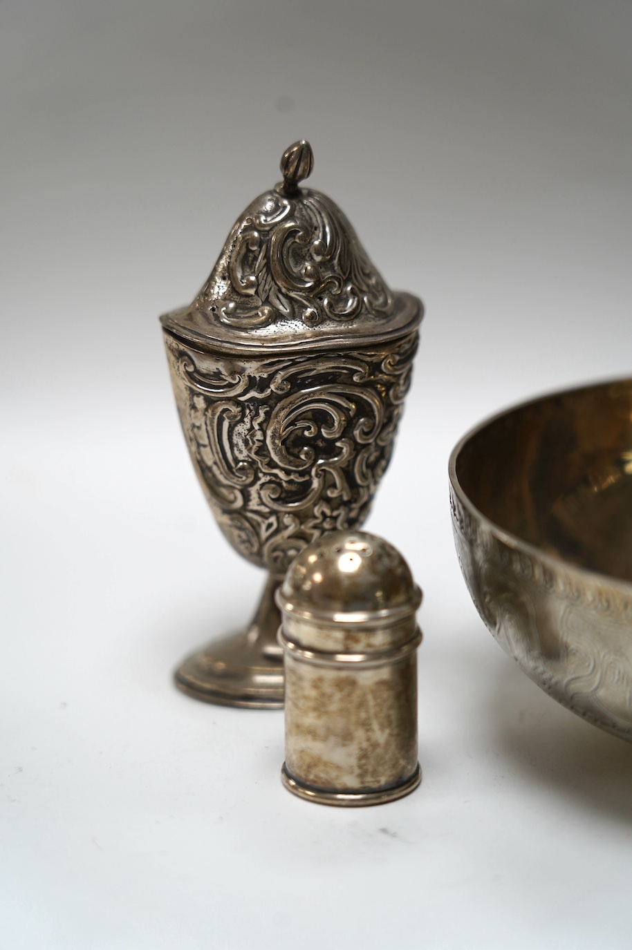 An Edwardian silver replica of a Mycenaean cup, Nathan & Hayes, Chester, 1912, height 62mm, together with a late Victorian silver mounted scent flask, two silver condiments and an Indian white metal box and cover. Condit